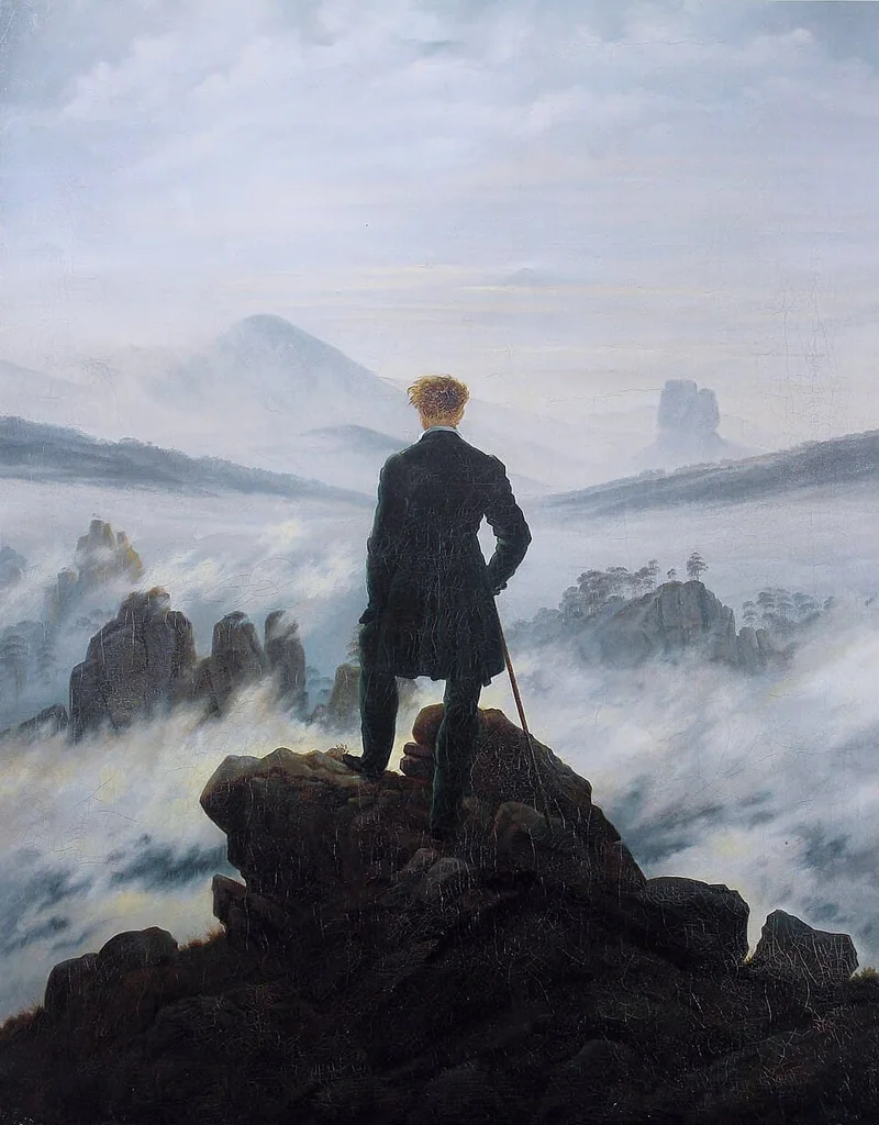 A man seen from behind, on a rocky peak, gazes over a sea of fog